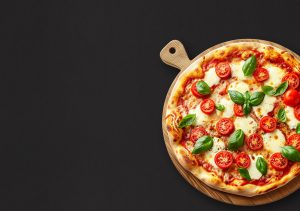 Pizza napolitaine cuite au feu de bois garnie de mozzarella, tomates fraîches et basilic.